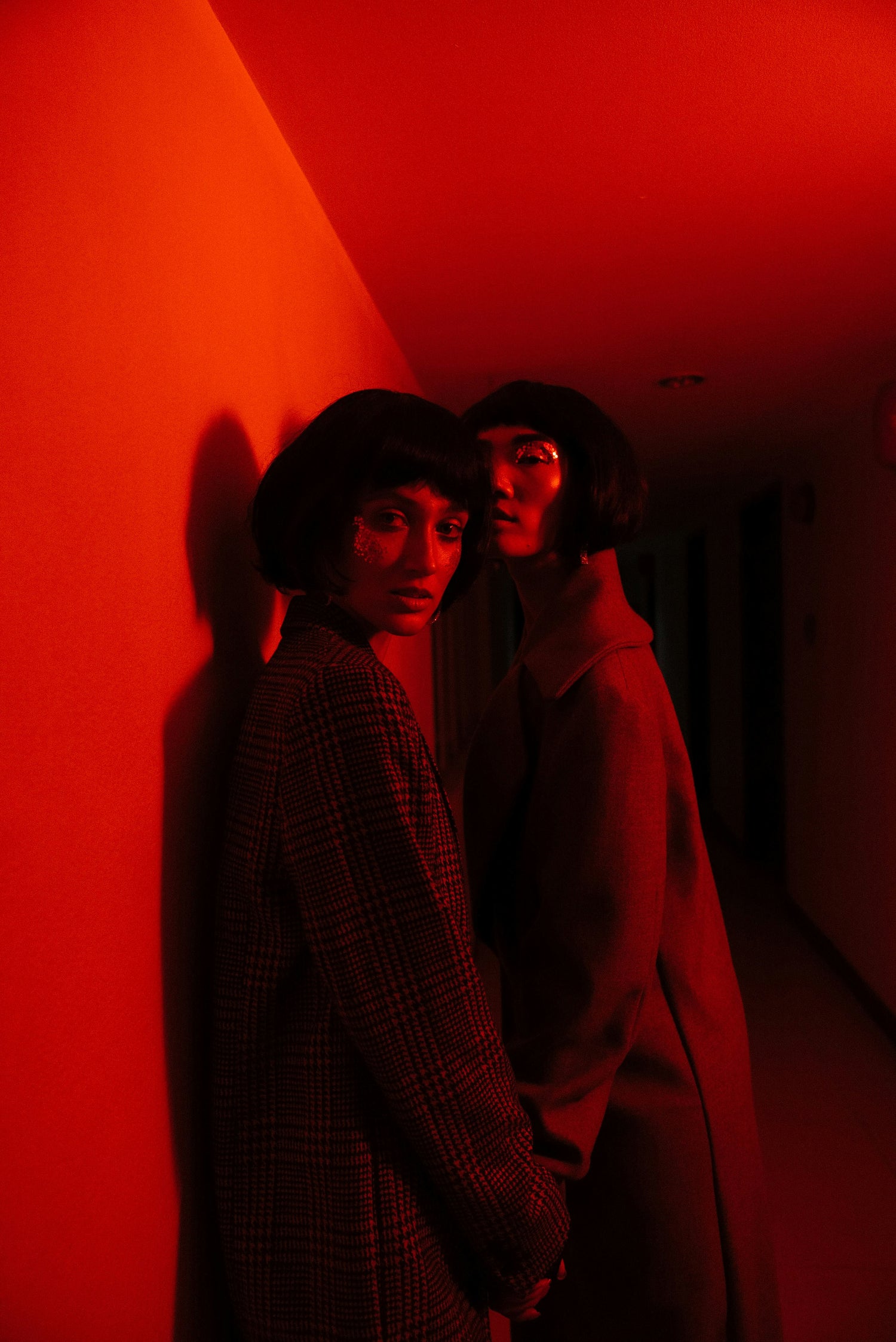 two fashion models in designer coats in editorial fashion shoot